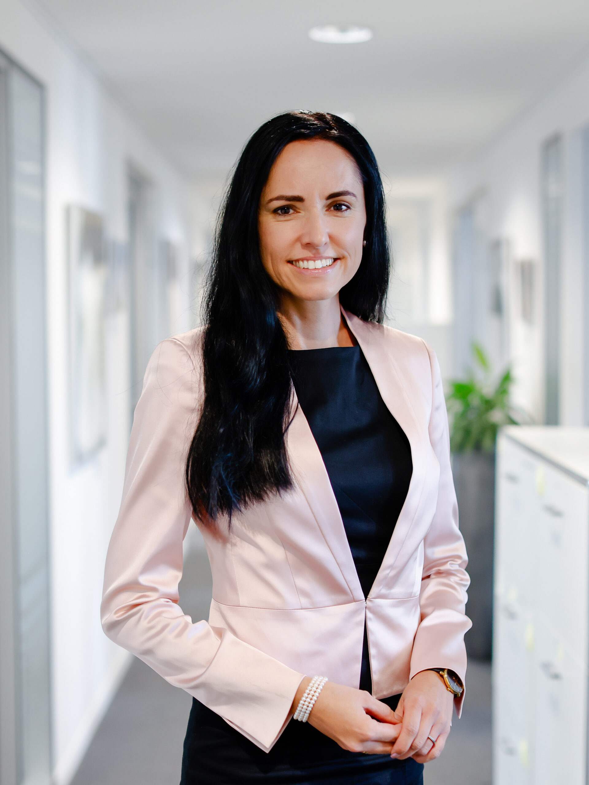Notariatsassessorin Simona Röhm sitzt lächelnd an ihrem Schreibtisch und unterzeichnet ein Dokument.