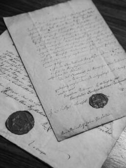 Handgeschriebene historische Dokumente und Urkunden mit offiziellen Wachssiegeln.